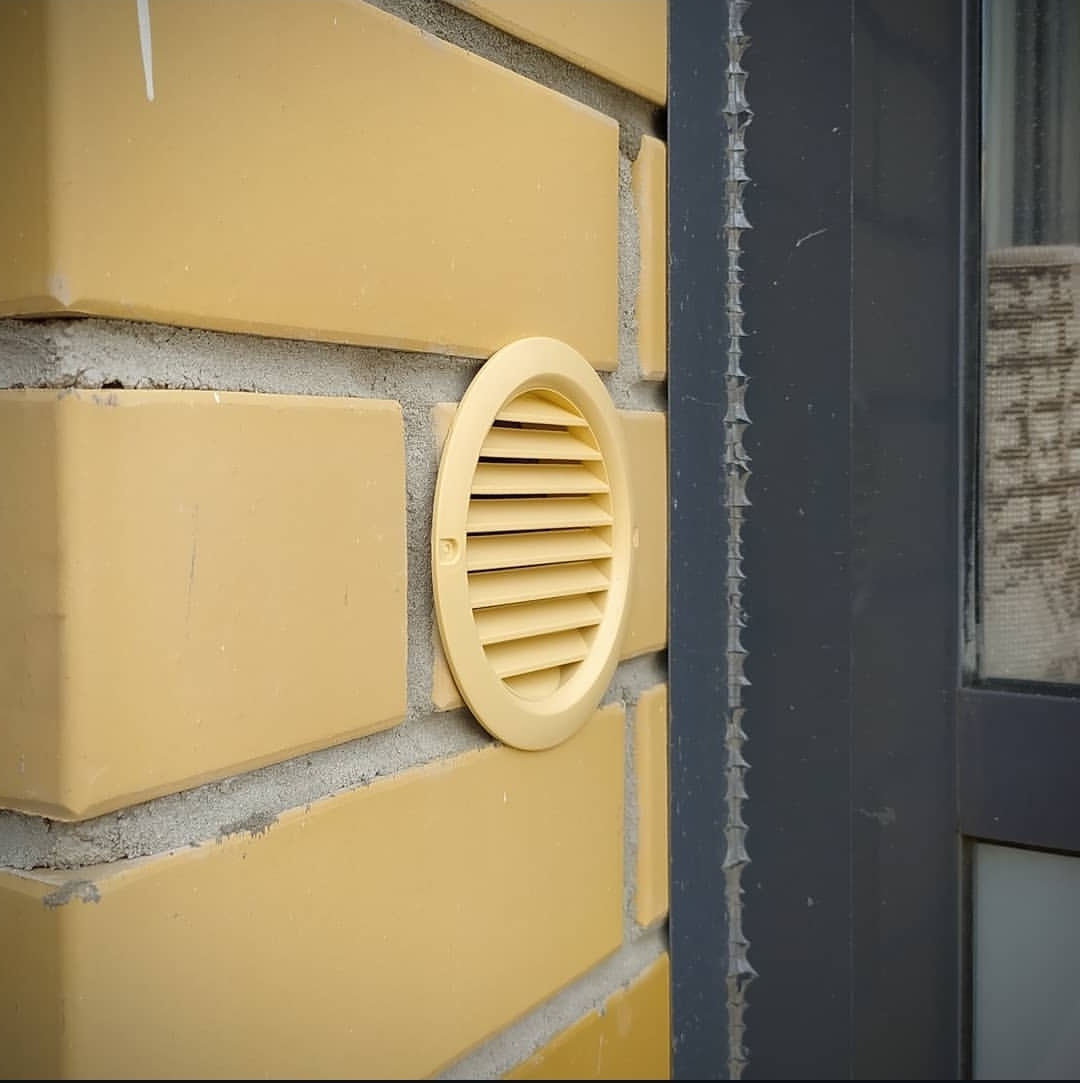 Кирпичный фасад, бризер установлен на откосе окна